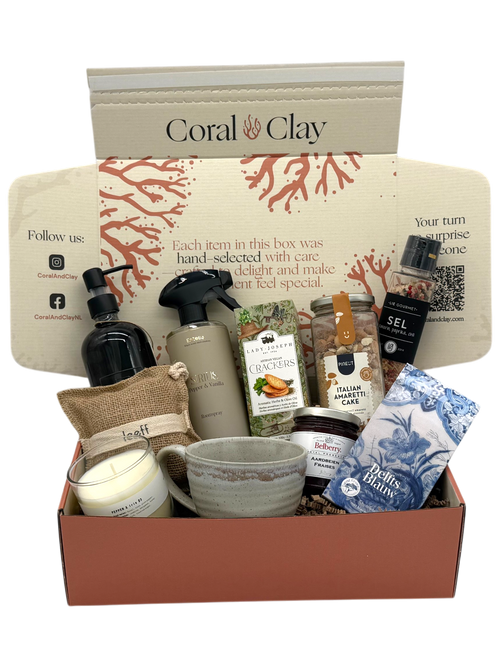 Gifting box with various items including a mug, soap, and bath products on a white background.