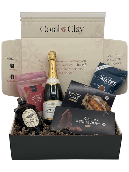 Gift basket with champagne, chocolate, and other items with 'Coral & Clay' branding.