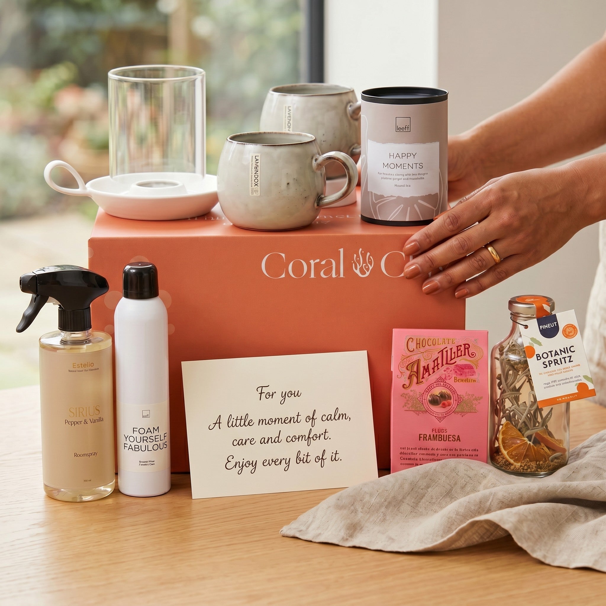 Coral & Clay Body & Mind Gift set with mugs, candles, and other items on a wooden surface.