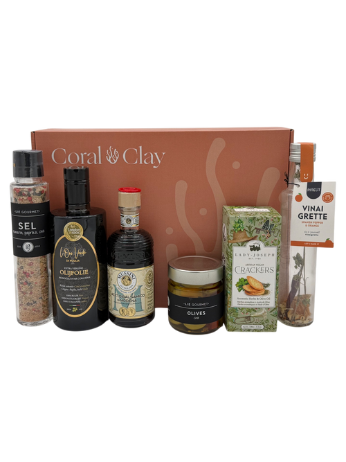 Collection of gourmet items including bottles, jars, and boxes with 'Coral Clay' branding on a white background.