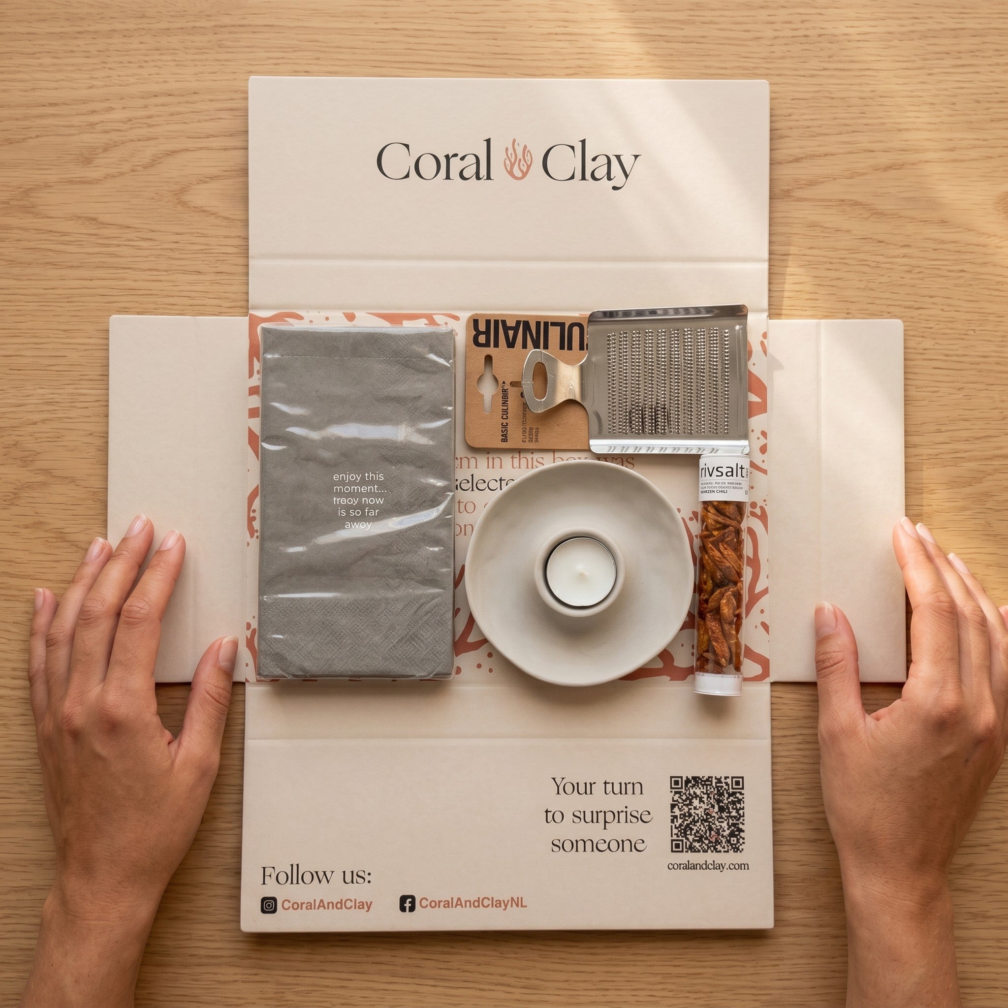 Coral & Clay product packaging on a wooden surface with hands holding it open.