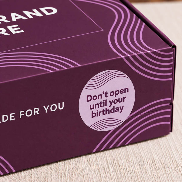 Birthday gift box sticker reading Don't open until your birthday on purple branded packaging