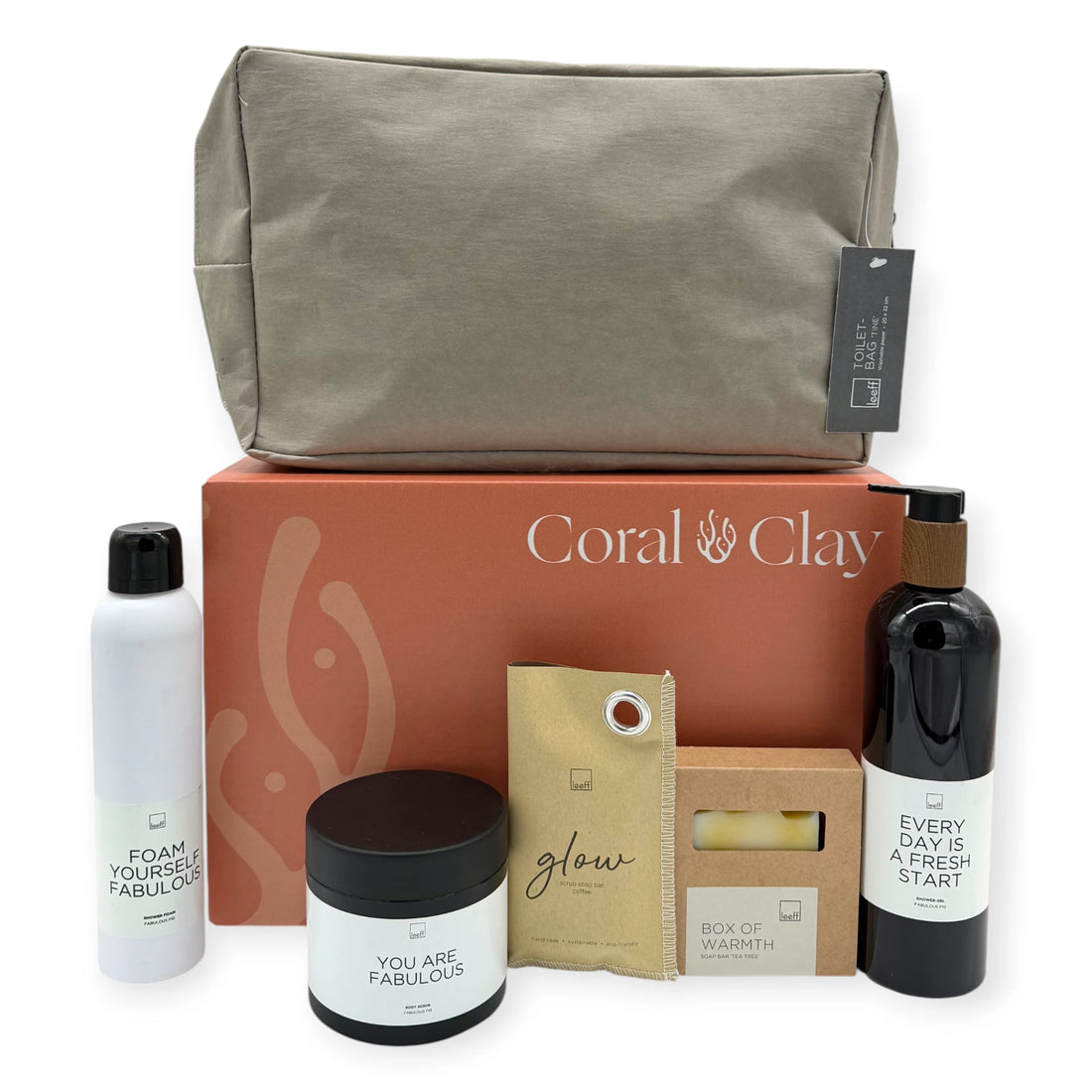 Grand Bath Retreat gift box displayed with Leeff bath and body essentials, Glow scrub soap bar, Box of Warmth soap bar, and a premium taupe toiletry bag arranged beside a Coral & Clay gift box.