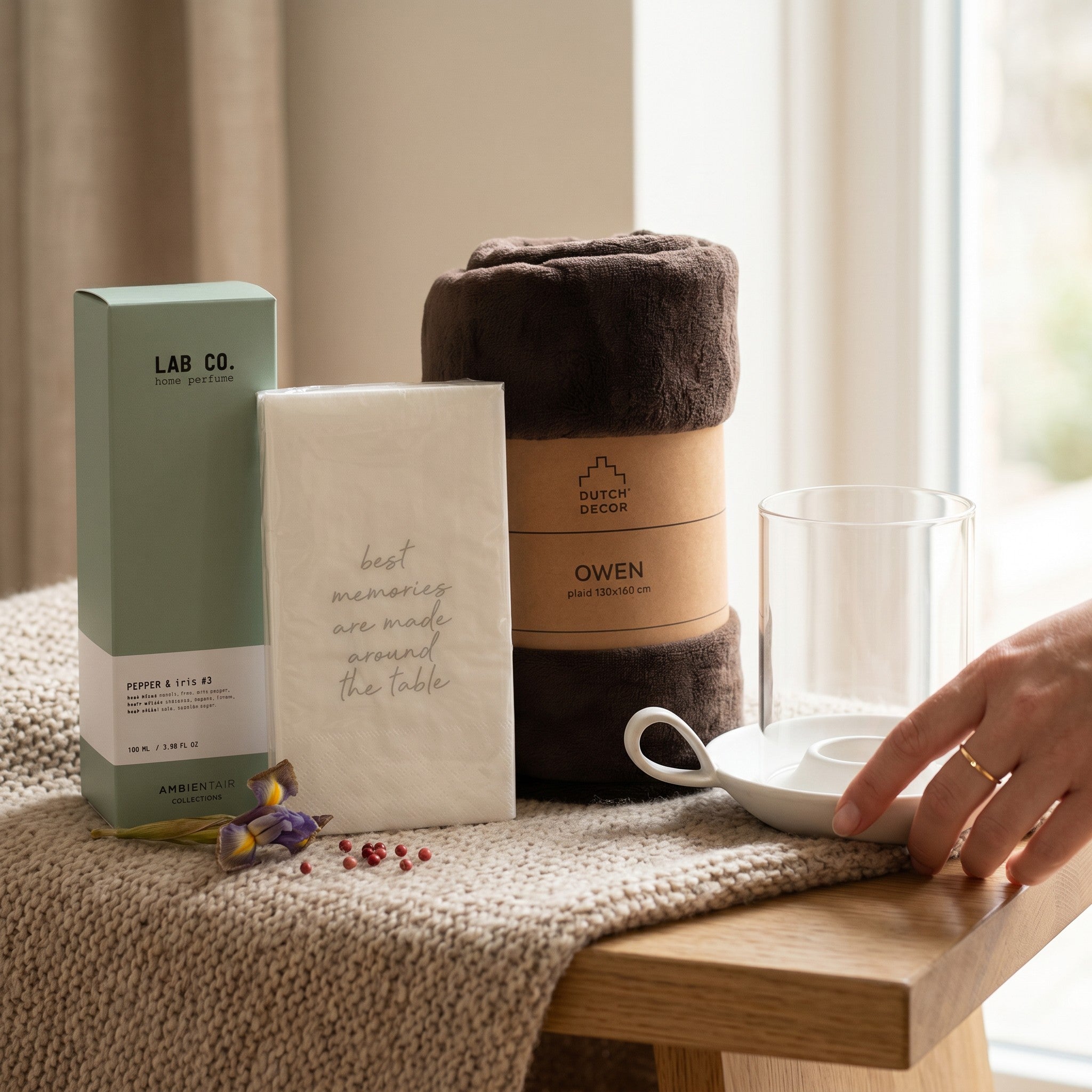 Product display on a table with a glass, small container, and wrapped item.