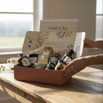 Coral & Clay signature gift box product set on a wooden table with a window in the background.