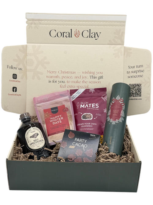 Gift box with various items including a bottle, packets, and a canister, branded 'Coral Clay'.
