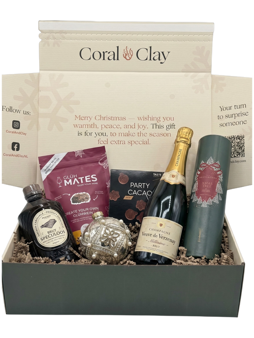 Gift box with various items including a bottle of wine, chocolate, and a bottle of gin, branded 'Coral & Clay'.