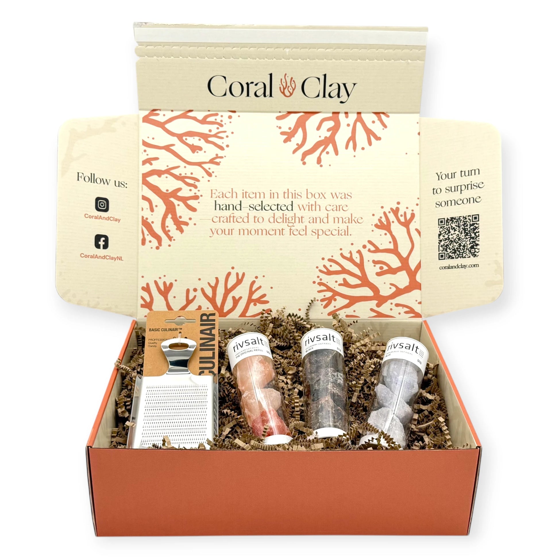 Top-down view of the Rivsalt Crystal Colours Signature Gift Box opened to reveal three Rivsalt salt rock tubes and a stainless-steel Culinair grater nestled in kraft paper filling.