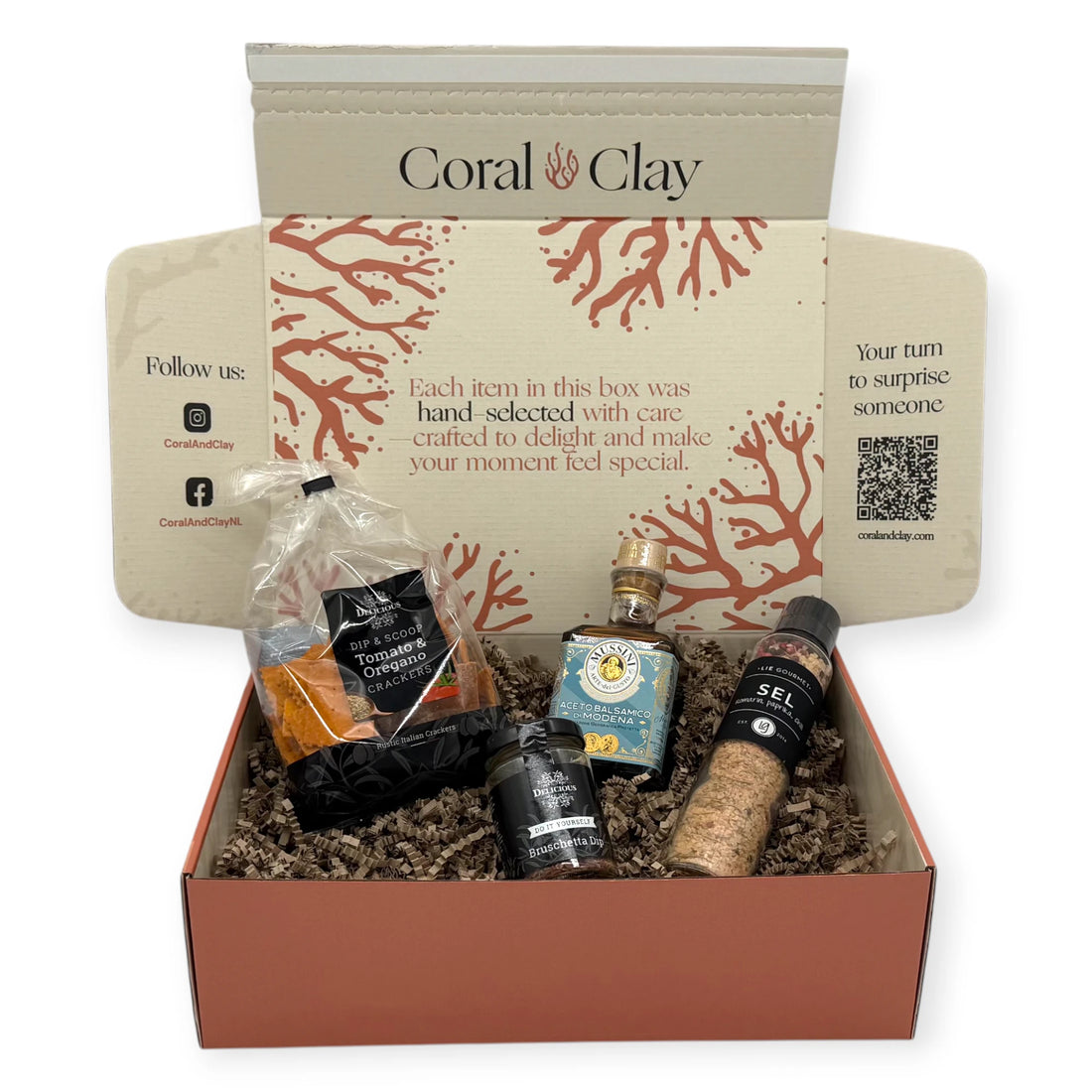 Gourmet cooking ingredients arranged in front of a Coral & Clay Signature Gift Box, featuring Lie Gourmet flavored salt, Mussini balsamic vinegar, Benolive rosemary olive oil, and two Delicious dip mixes.