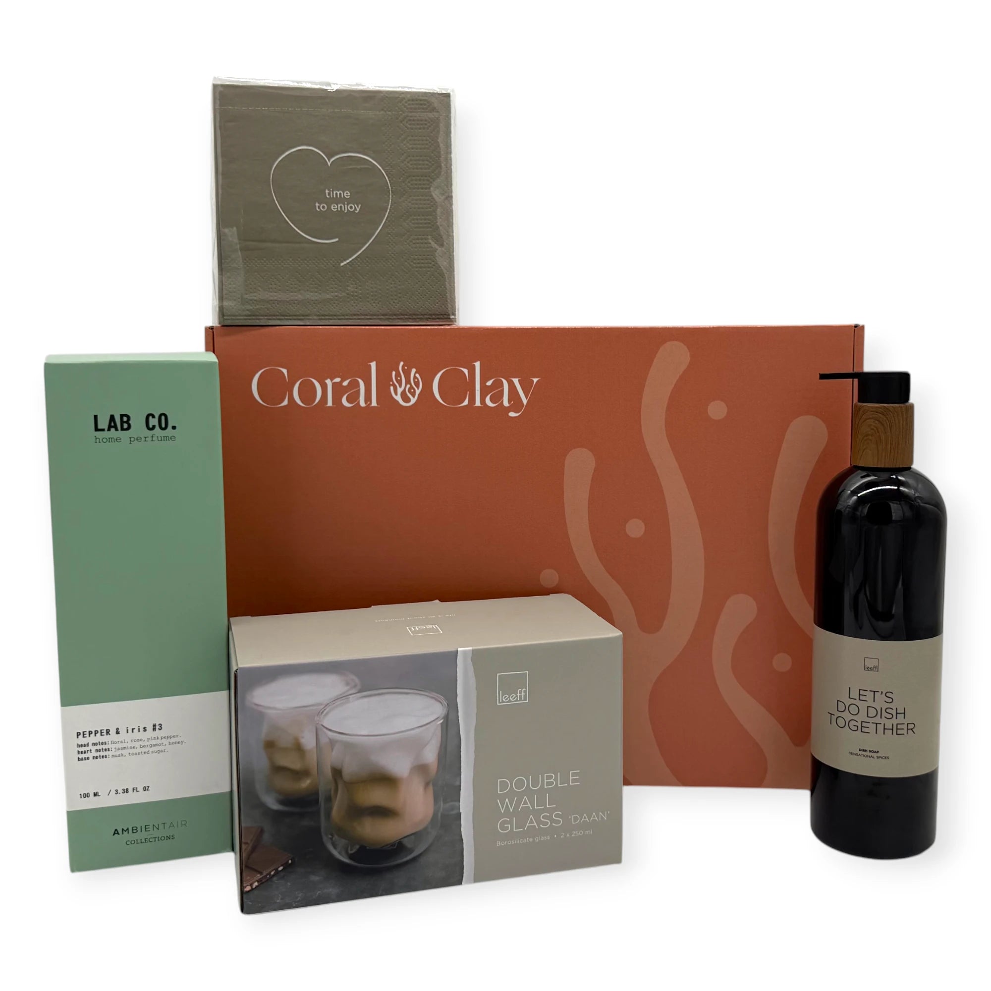 Home Haven Signature Gift displayed in front of a Coral & Clay Signature box, featuring napkins, double-wall glasses, Pepper & Iris home perfume, and dish soap.