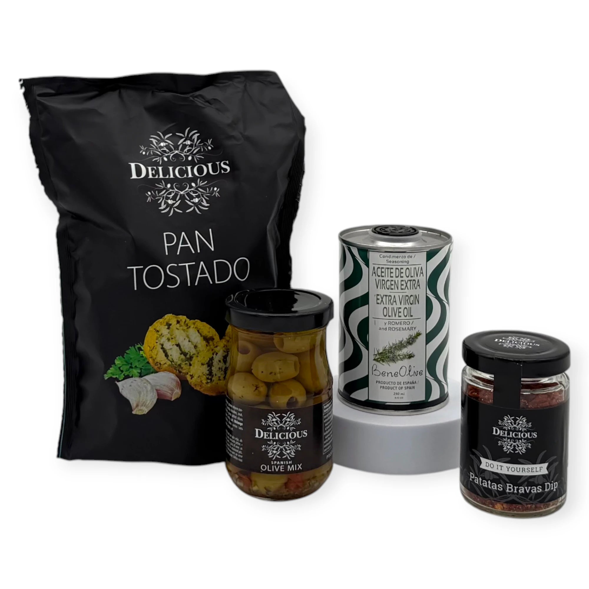 Taste of Spain gift box contents displayed on a white background, featuring Pan Tostado garlic crispbread, a jar of seasoned olive mix, BeneOlive rosemary olive oil, and a Patatas Bravas spice dip mix.