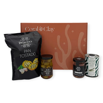 Taste of Spain gift box with Pan Tostado crispbread, seasoned olive mix, Patatas Bravas dip mix, and BeneOlive rosemary olive oil arranged in front of the closed Coral & Clay signature box.