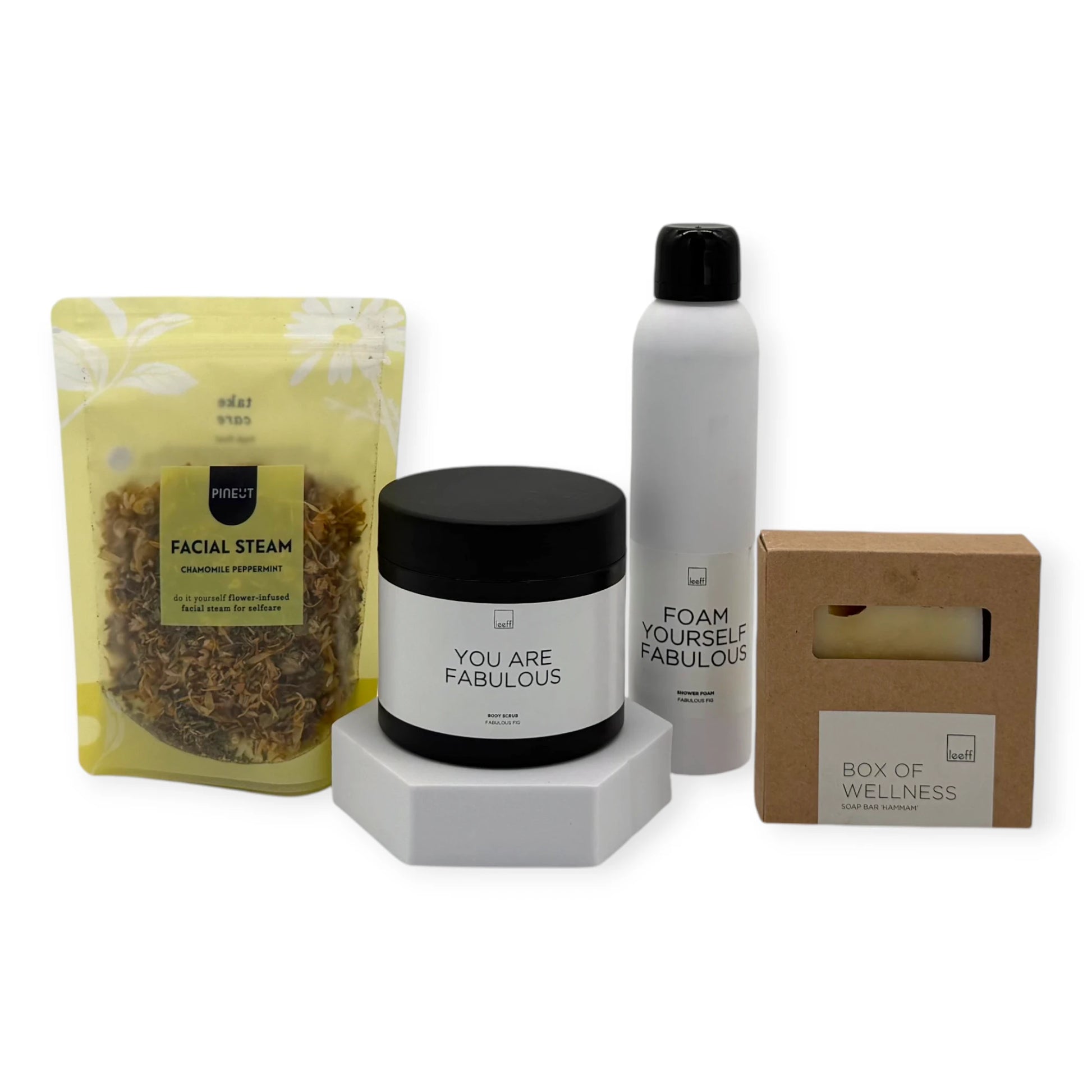 Contents of the Signature Wellness Ritual gift box featuring Leeff Foam Yourself Fabulous shower foam, You Are Fabulous body scrub, Box of Wellness soap bar, and Pineut Facial Steam.