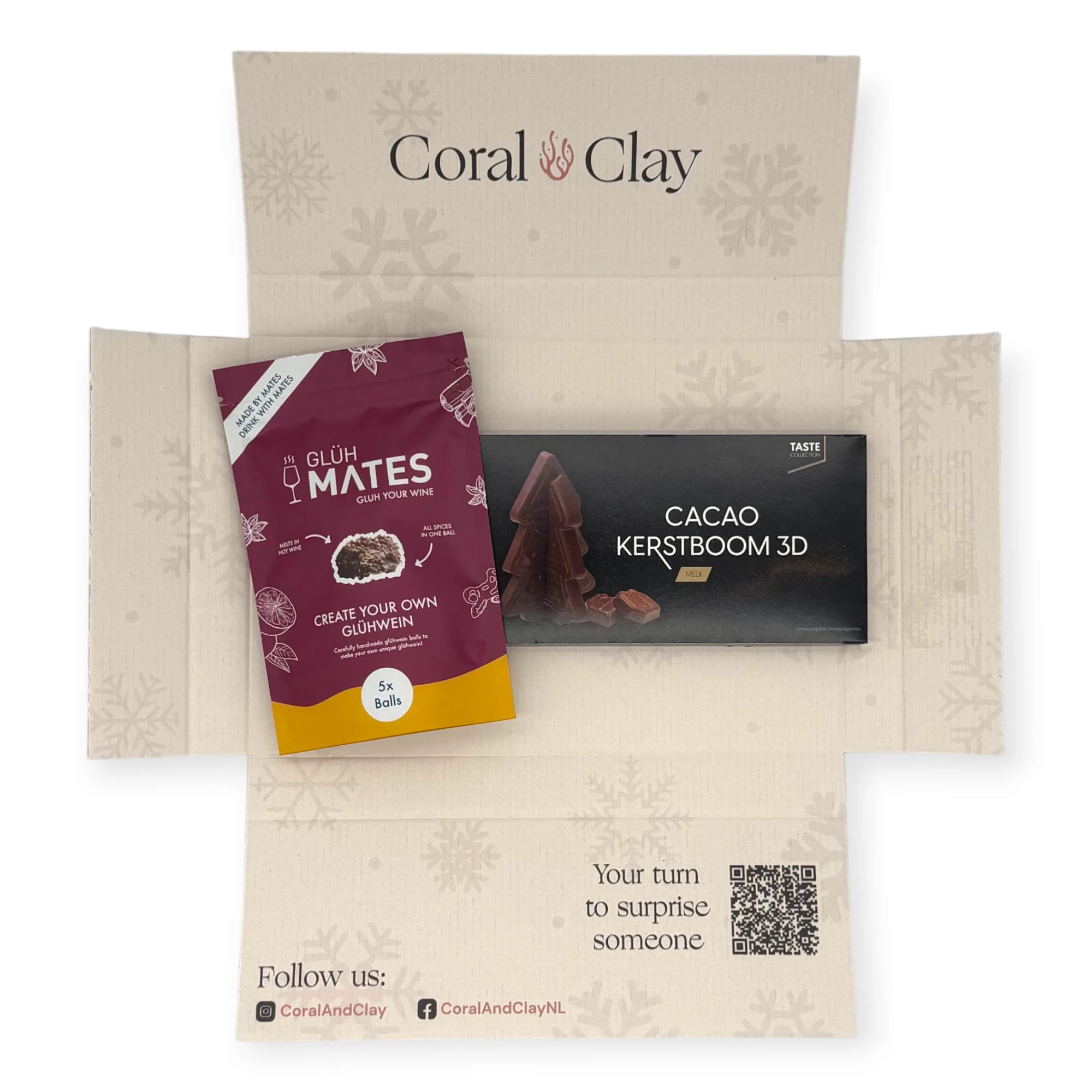 Top-down view of the Coral & Clay Festive Flavours Christmas Letterbox Gift opened to reveal Glüh Mates glühwein mix and the 3D milk chocolate Christmas tree inside the snowflake-printed box.
